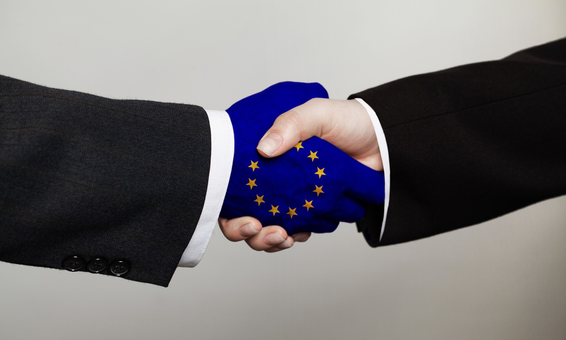 Cooperation and business with handshake. Male handshake with the EU flag. Support concept